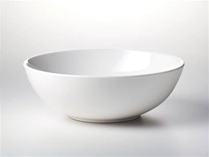 Closeup of a white bowl filled with scoops of rocky road ice cream.