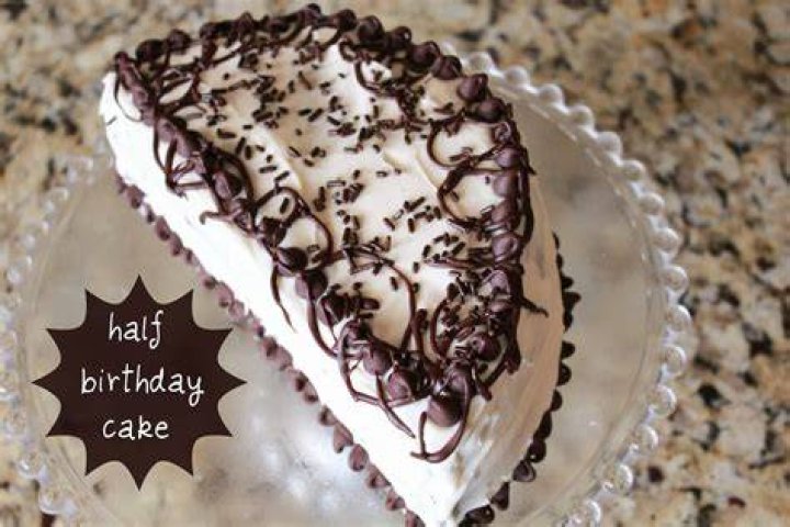 Half birthday cake with white frosting and colored sprinkles.