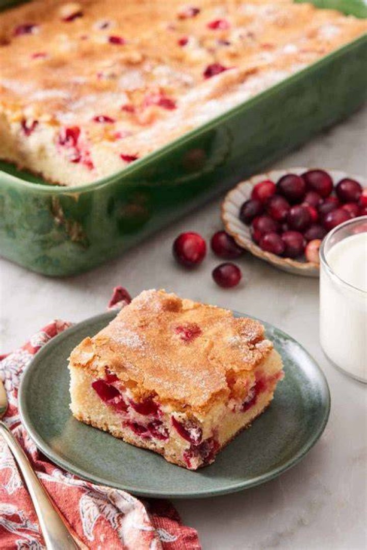 Slice of cranberry cake on a green and white plate.